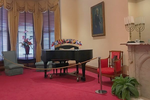 a room with a piano and decorative furniture