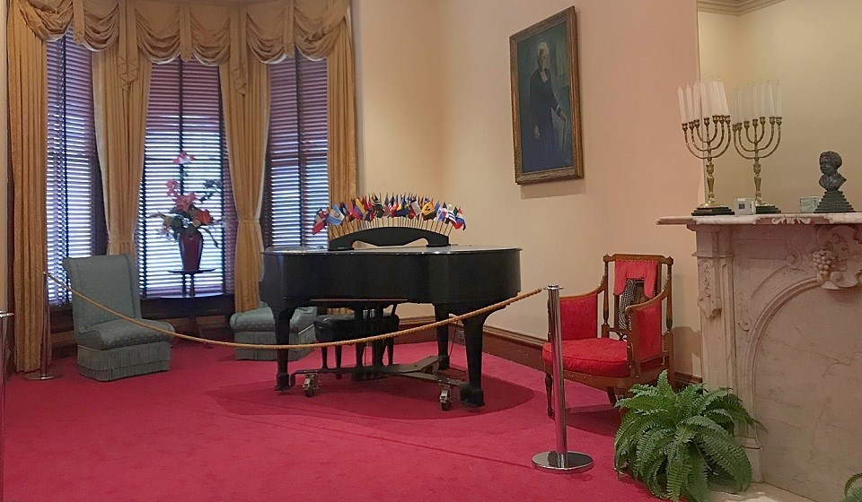 a room with a piano and decorative furniture